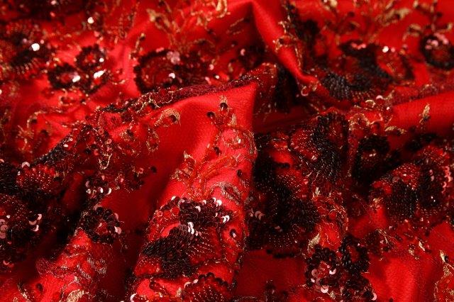 Ref 1354 tulle brode de motifs de fleurs en fils dores et paillettes presente sur fond satin rouge