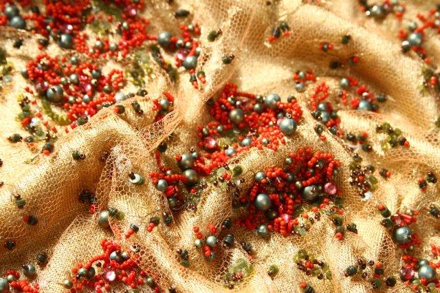 Ref 1355 tulle dore perle de perles rouges vertes presente sur fond de jersey lame